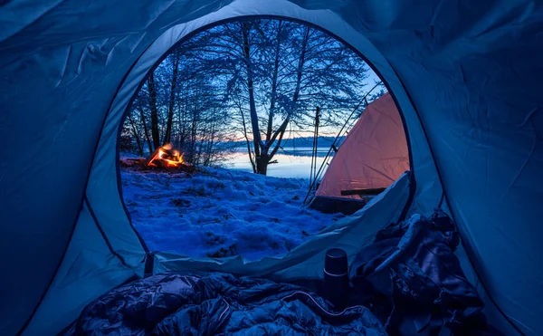 Läger vid sjön med lägereld i skymningen på vintern — Stockfoto