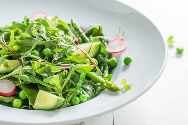 Крупный план зеленого салата со шпинатом, редиской и спаржей — стоковое фото