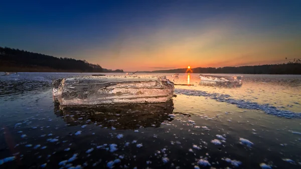 Krásné zmrzlé zimní jezero s kusem ledu při západu slunce — Stock fotografie