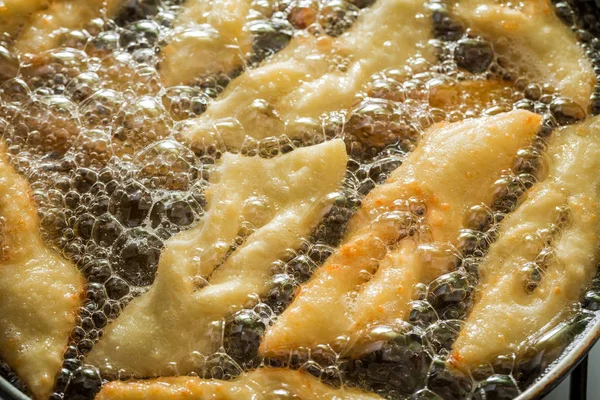 Крупный план жарки вкусных и домашних пончиков на масле — стоковое фото