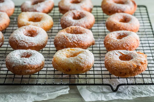 Zelfgemaakte donuts met poedersuiker op metaal rasp — Stockfoto