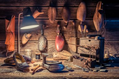 Vintage shoemaker workplace with brush, shoes and shoelaces clipart