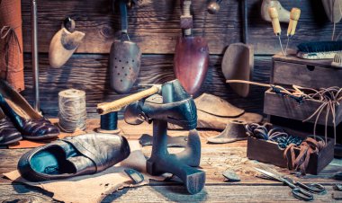 Vintage shoemaker workshop with tools and shoes clipart