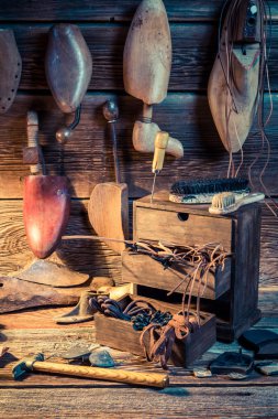 Closeup of cobbler workplace with shoes, tools and laces clipart