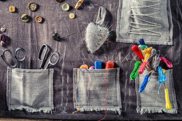 Fil coloré, ciseaux et boutons dans un tapis de tailleur — Photo