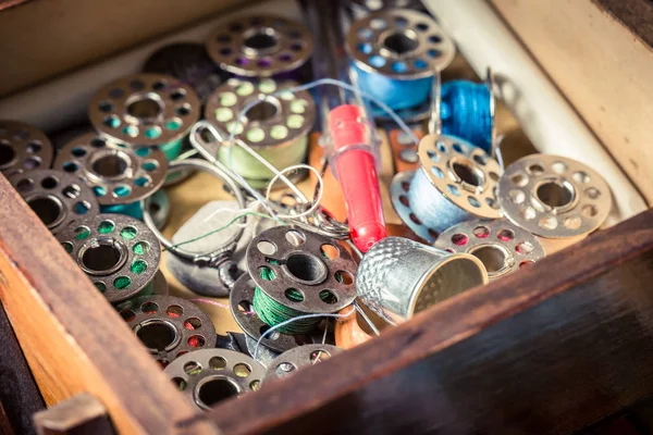 Threads, needles and buttons in tailor's wooden box — Stock Photo, Image