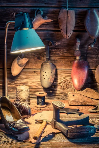 Oficina de sapateiro com ferramentas, couro e sapatos para reparar — Fotografia de Stock
