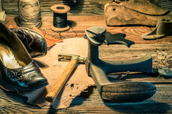 Fechar o local de trabalho do sapateiro com sapatos, ferramentas e cadarços — Fotografia de Stock