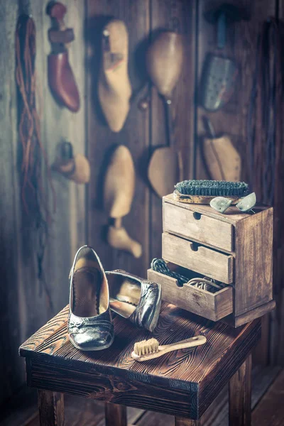 Brush and shoes in vintage shoemaker workshop — Stock Photo, Image