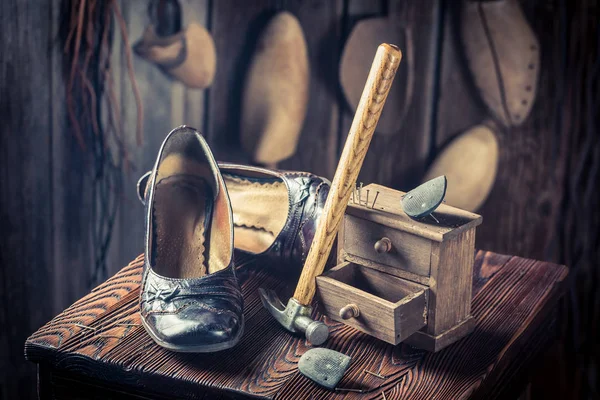 Envelhecido sapateiro local de trabalho com sapatos, martelo e unhas — Fotografia de Stock
