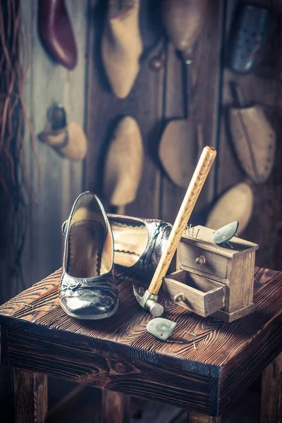 Primer plano del lugar de trabajo del zapatero con zapatos, clavos y martillo —  Fotos de Stock