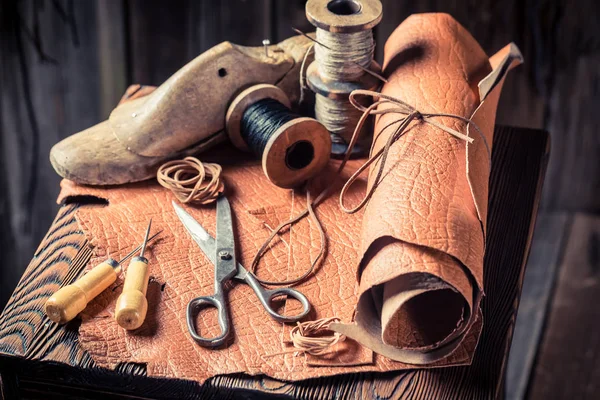 Lugar de trabajo del zapatero con herramientas, cuero e hilos — Foto de Stock
