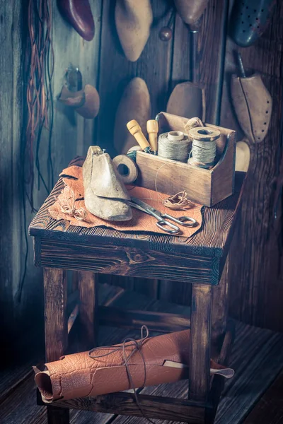 Сапожное рабочее место с инструментами, обувью и нитками — стоковое фото