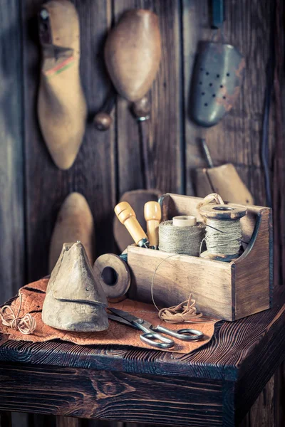 Шнурки и инструменты на рабочем месте старого сапожника — стоковое фото