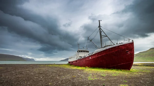 Schiffbruch am Ufer bei bewölktem Tag, Island — Stockfoto