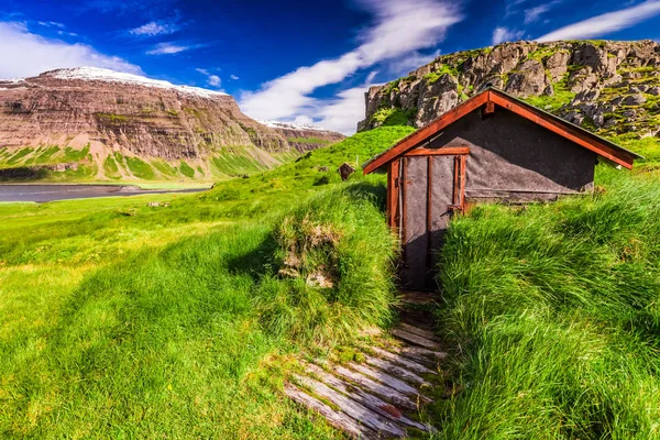 Pequeña cabaña de montaña en la colina verde cubierta de hierba, Islandia —  Fotos de Stock
