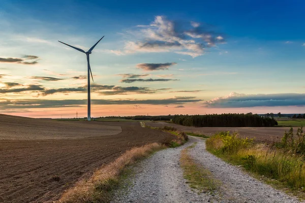 Sunset at brown field with wind turbine in autumn, Poland — Stock Photo, Image