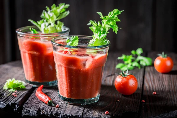 Bloody Mary cóctel con tomates y hielo en la mesa de madera —  Fotos de Stock