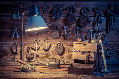 Old tools, locks and keys in locksmiths workshop clipart
