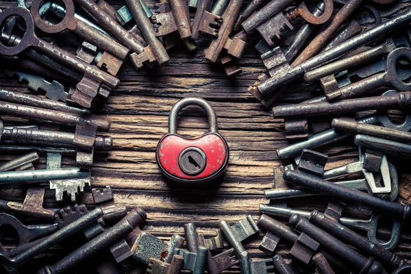 Ένα κόκκινο κλειδαριά και πολλά παλιά κλειδιά ως έννοια — Φωτογραφία Αρχείου