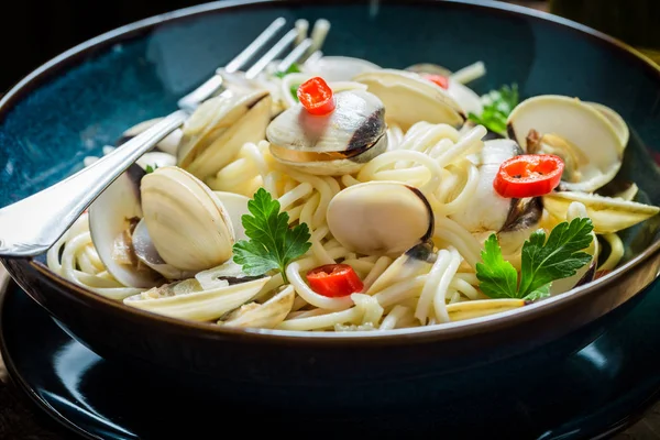 Закрытие макаронных изделий из морепродуктов из моллюсков, перца и петрушки — стоковое фото