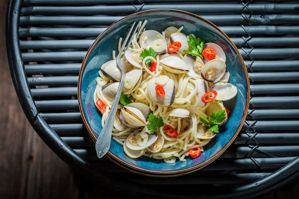 Zeevruchten pasta met venusschelpen, peterselie en paprika op zwarte lijst — Stockfoto