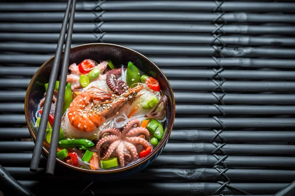 Nikmati mie seafood Anda dalam mangkuk gelap di atas meja hitam — Stok Foto
