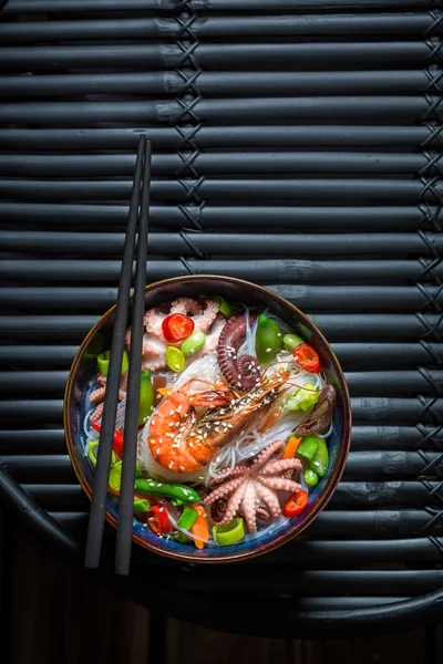 Mie seafood lezat dengan udang dan gurita di atas meja hitam — Stok Foto