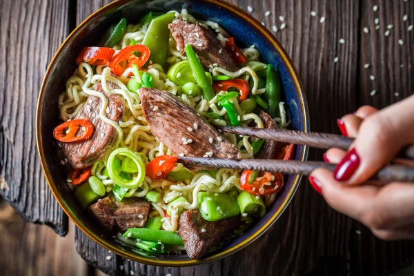 Mie Asia lezat dengan cabai daging sapi di atas meja kayu — Stok Foto