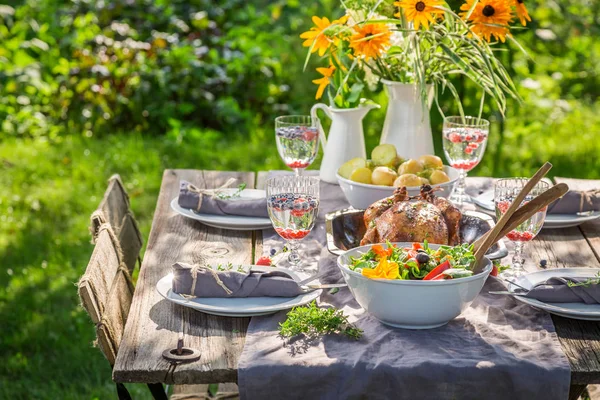 Δείπνο με κοτόπουλο και σαλάτα που σερβίρεται στον κήπο το καλοκαίρι — Φωτογραφία Αρχείου