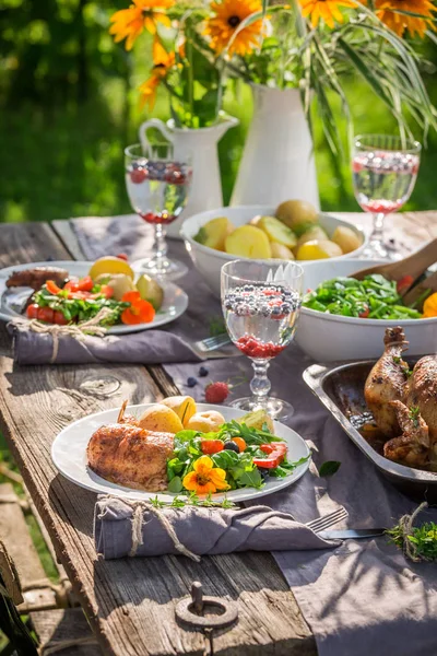 Σπιτικό γεύμα με σαλάτα και το κοτόπουλο σε καλοκαιρινό κήπο — Φωτογραφία Αρχείου