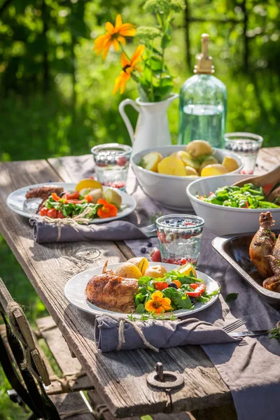Δείπνο με κοτόπουλο και λαχανικά που σερβίρεται στον κήπο το καλοκαίρι — Φωτογραφία Αρχείου