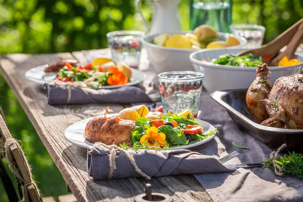 Primer plano de la cena con pollo y verduras en el jardín —  Fotos de Stock