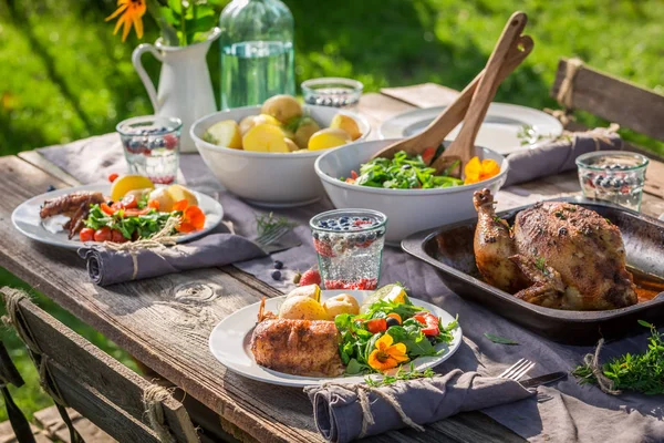 Abendessen mit Hühnchen, Salat und Kartoffeln im Garten — Stockfoto