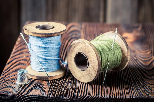 Fechar a agulha vintage e os fios na mesa de madeira — Fotografia de Stock