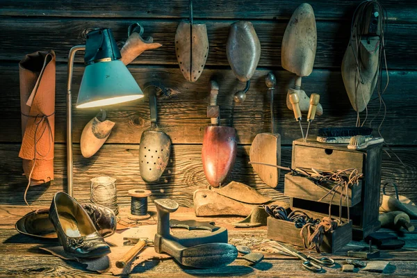 Oficina sapateiro rústico com sapatos para reparar e ferramentas — Fotografia de Stock