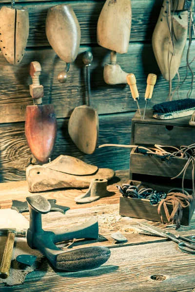 Обувщик рабочее место с инструментами, кожей и обувью для ремонта — стоковое фото