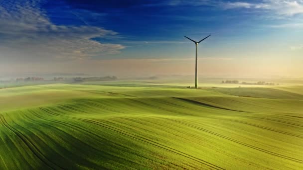 Maravilhosa turbina eólica nebulosa no campo verde ao nascer do sol, Polônia — Vídeo de Stock