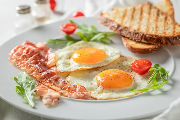 Lukking av frokost med ristet brød, bacon, egg og tomater – stockfoto