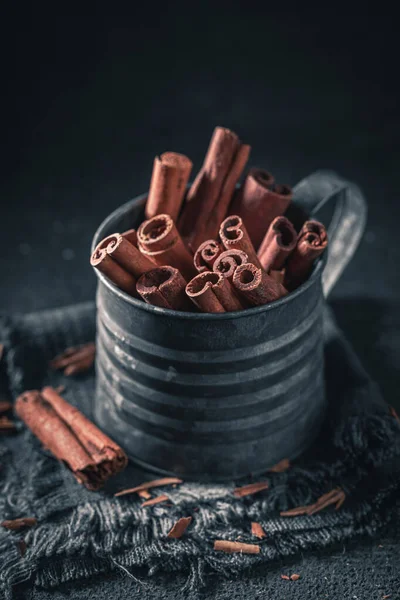 Aromatic cinnamon sticks in old metal mug — Stock Photo, Image