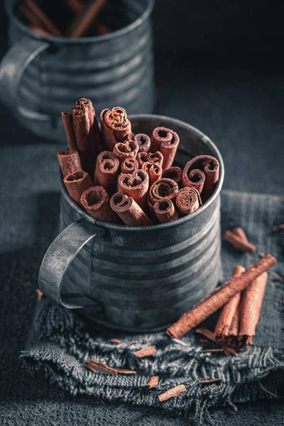 Closeup of cinnamon sticks in old metal mug — Stock Photo, Image