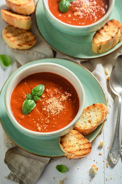 Delicious and creamy tomato soup with basil and toasts — Stock Photo, Image