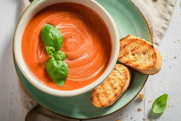 Sopa de tomate quente e cremosa com manjericão e torradas — Fotografia de Stock