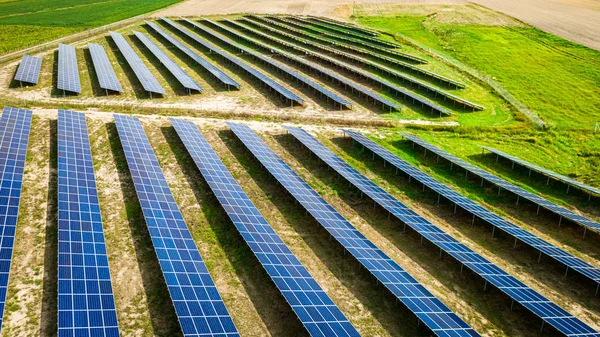 Volando por encima de la vista de paneles solares en el campo verde —  Fotos de Stock