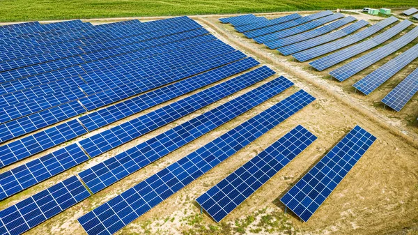 Painéis solares grandes e azuis no campo seco no verão — Fotografia de Stock