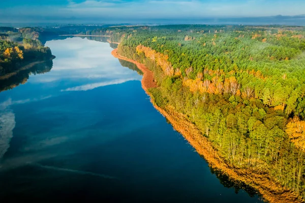 Floresta e lago azul claro com reflexão chemtrail, vista aérea — Fotografia de Stock