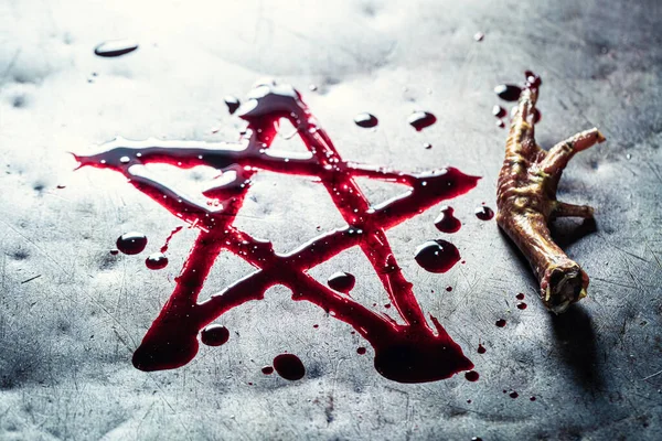 Pentagram drawn from blood on metal table with crow's paw — Stock Photo, Image