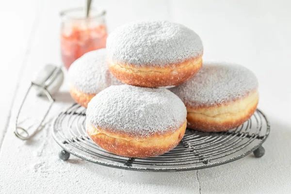 Коричневые пончики с белой глазурью на белом столе — стоковое фото