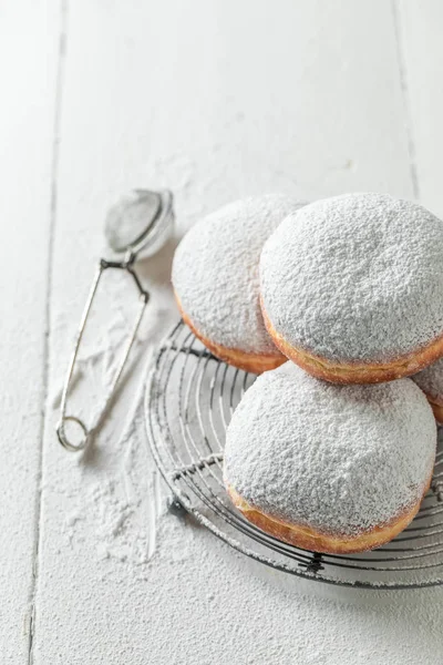 Пончики с сахарной пудрой на белом столе — стоковое фото