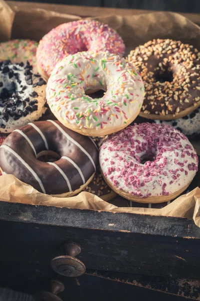 Donuts doces em caixas de madeira velhas com papel manteiga — Fotografia de Stock